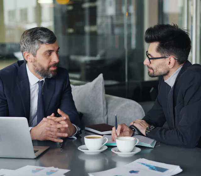Deux hommes en discussion à une table de réunion